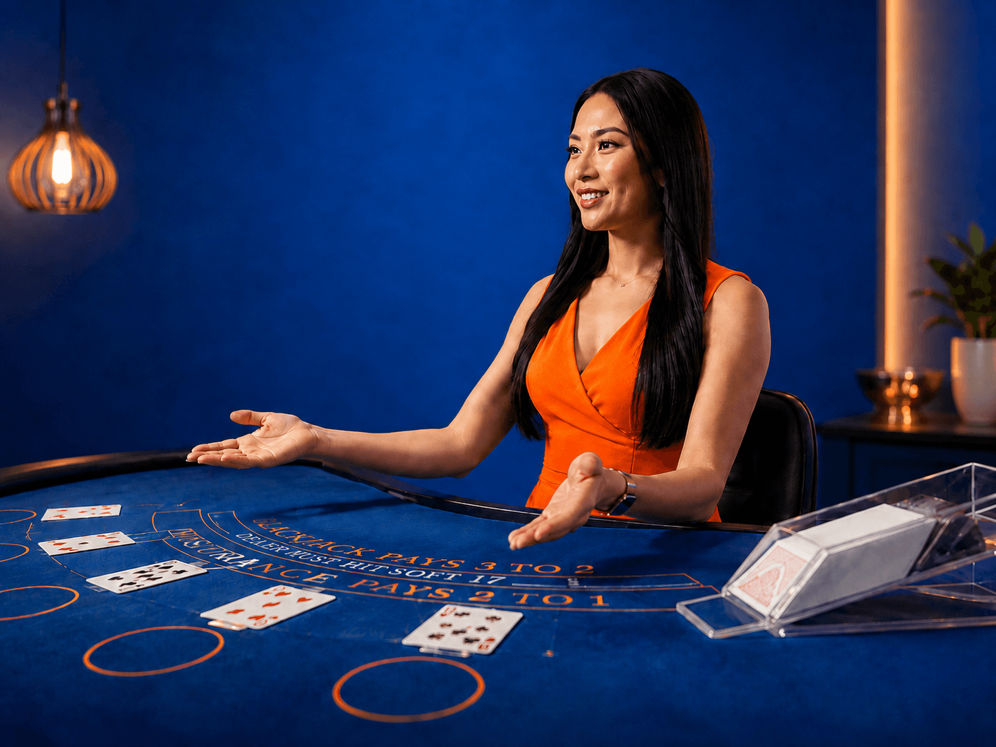 Live casino dealer presenting a blackjack table with playing cards in a professional BetGames gaming studio